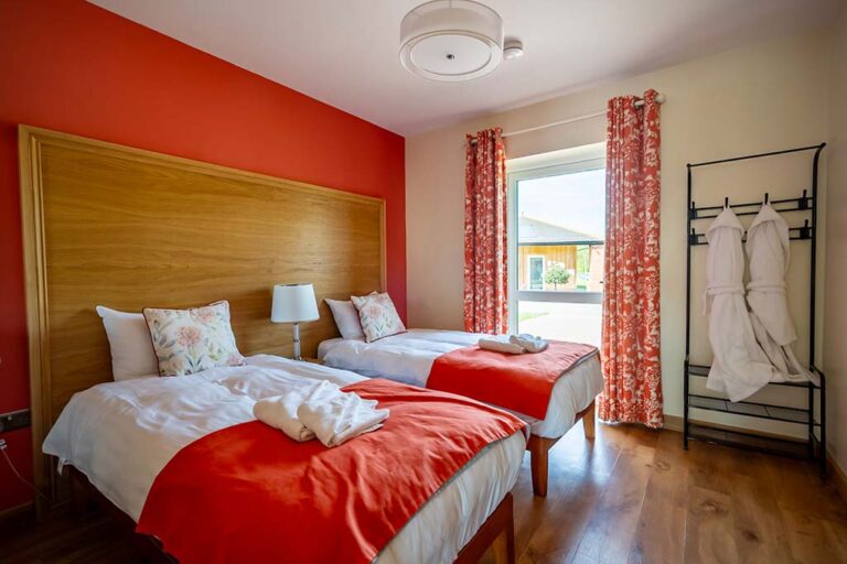 A twin bedroom from a log cabin available to hire at Flaxton Meadows